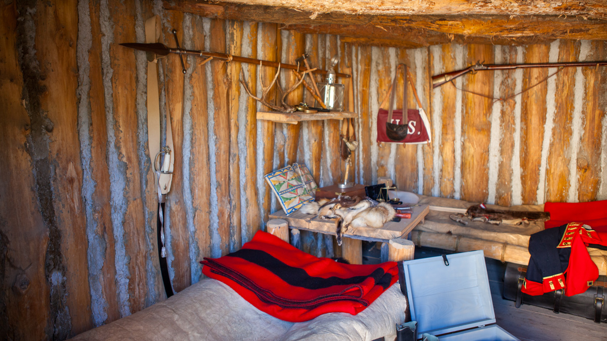 Log cabin with two beds and a table