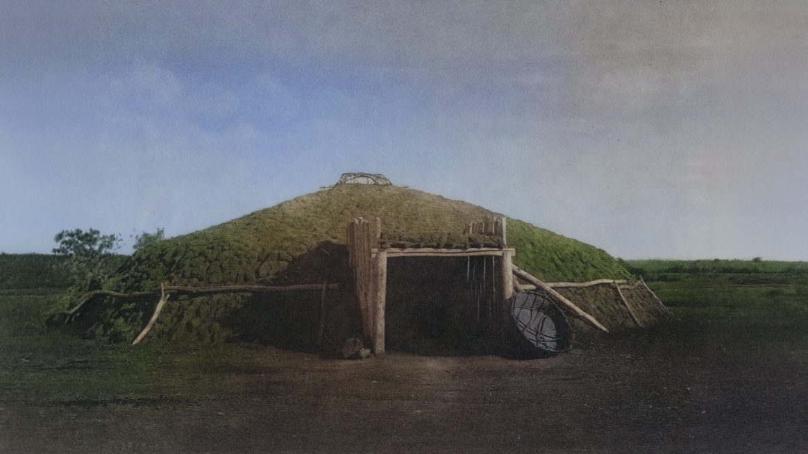 Historic photo of a large round hut covered in earth