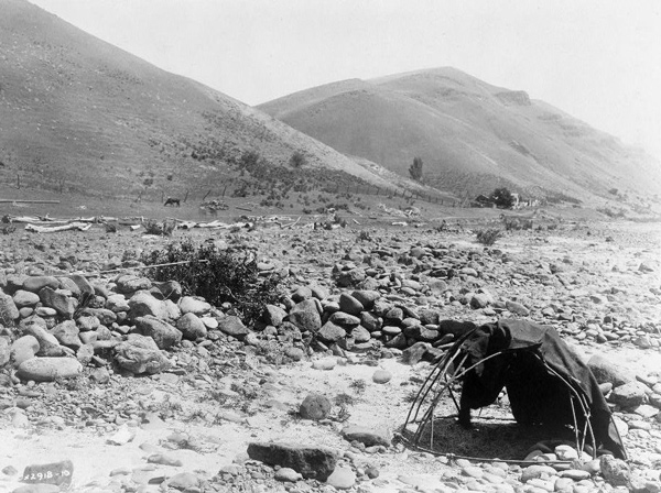 Large rocks on a dry river shore and a small domed shelter