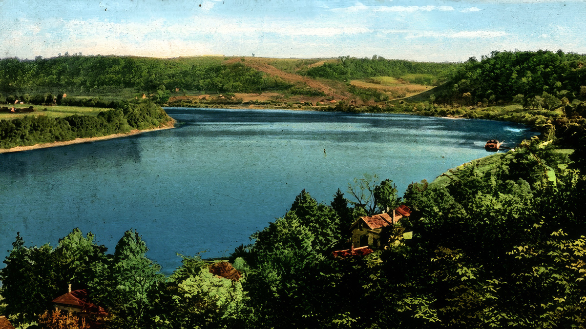 Postcard of Ohio with flat field on the left bank, and forested hills on the right