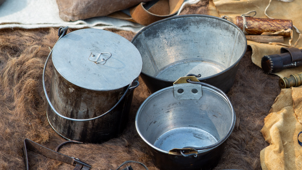 Fire-charred tin and brass kettles
